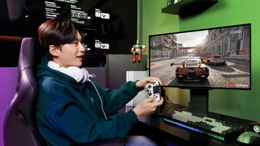 A young man plays a racing game on a fancy display. 
