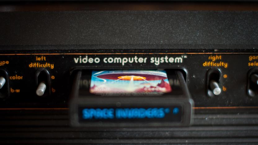 [UNVERIFIED CONTENT] Atari 2600 VCS console, close up of inserted cartridge and central switches. Space Invaders game is inserted. Difficulty switches visible. Narrow depth of field. Dust visible.