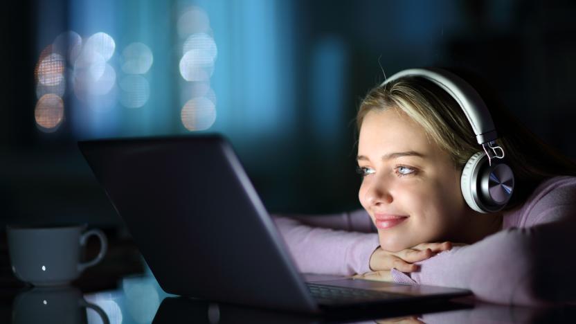 Teen wearing headphones watching media on laptop