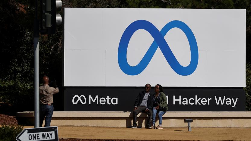 People pose in front of a sign of Meta, the new name for the company formerly known as Facebook, at its headquarters in Menlo Park, California, U.S. October 28, 2021. REUTERS/Carlos Barria