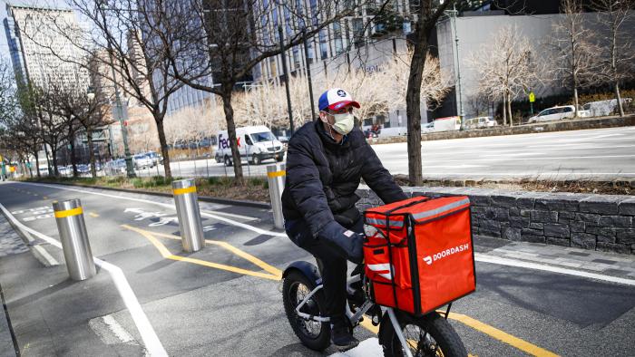 FILE - In this March 16, 2020 file photo, a delivery worker rides his bicycle along a path on the West Side Highway in New York. New York City was ordered Friday, July 7, 2023, to temporarily delay new minimum pay standards for food delivery workers after being sued by Uber Eats, DoorDash and Grubhub. (AP Photo/John Minchillo, File)
