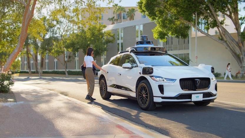 A person reaching out to open the backdoor of a Waymo robotaxi. Serene treelined street.