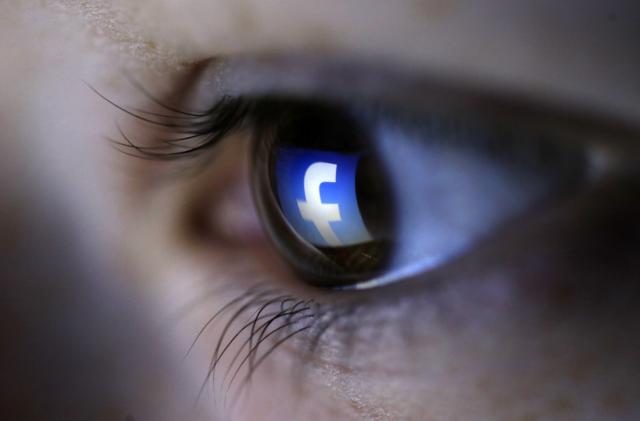 A picture illustration shows a Facebook logo reflected in a person's eye, in Zenica, March 13, 2015. Facebook Inc recorded a slight increase in government requests for account data in the second half of 2014, according to its Global Government Requests Report, which includes information about content removal.Requests for account data increased to 35,051 in the second half of 2014 from 34,946 in the first half, with requests from countries such as India rising and those from others including United States and Germany falling, the report by the world's largest Internet social network showed. Facebook said it restricted 9,707 pieces of content for violating local laws, 11 percent more than in the first half, with access restricted to 5,832 pieces in India and 3,624 in Turkey. Picture taken on March 13. REUTERS/Dado Ruvic (BOSNIA AND HERZEGOVINA - Tags: SOCIETY PORTRAIT SCIENCE TECHNOLOGY BUSINESS TELECOMS TPX IMAGES OF THE DAY)