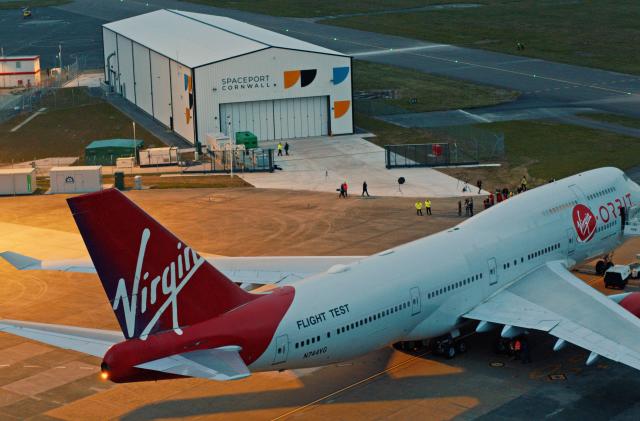 A Virgin Orbit flight text plane sits near a runway terminal in Cornwall England.