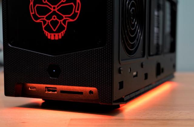 A photo of a black computer case with a skull design on top of a wooden table.