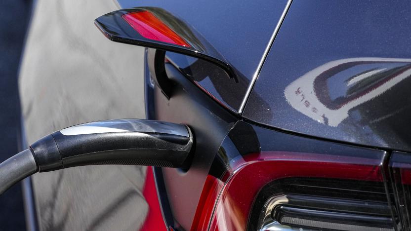 File - A Tesla vehicle receives a charge at a charging station, Sept. 28, 2023, in Woodstock, Ga. Tesla is expected to report fourth quarter and full year sales Tuesday as electric vehicle sales growth continues to slow. (AP Photo/Mike Stewart, File)