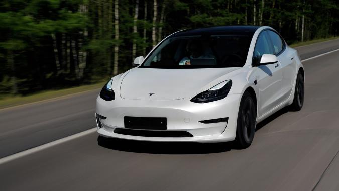 Minsk, Belarus - April 15, 2021: Tesla Model 3 Performance 2021 MY drives on a highway. It has dual-motor all-wheel drive, total output is 451 hp. Model 3 is the best-selling plug-in electric vehicle.