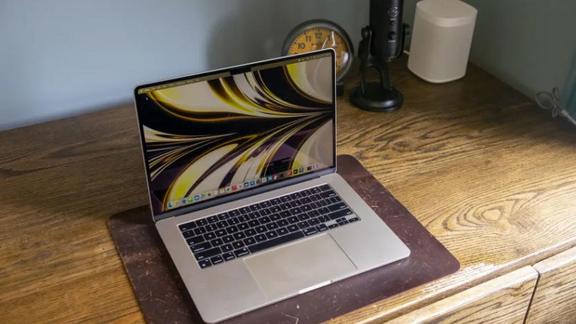 Image of the MacBook Air 15, 2023, on a hardwood bench, with an alarm clock, microphone and Sonos speaker in the background.