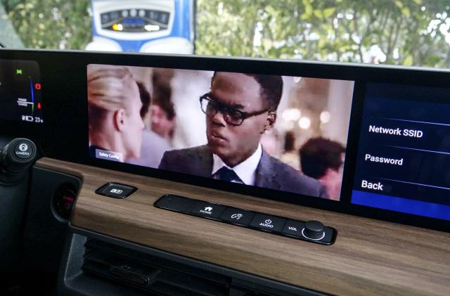 A close-up of a modern car's dashboard with built-in display showing a TV show, as an example of how UK regulators will allow drivers watch TV in self-driving cars.