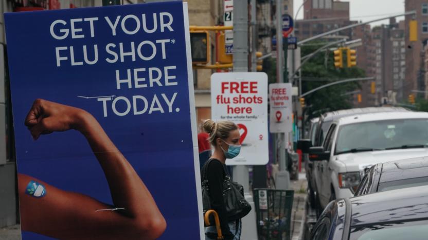 A woman walks past free flu shot advertisements outside of drugstores on August 19, 2020 in New York. (Photo by Bryan R. Smith / AFP) (Photo by BRYAN R. SMITH/AFP via Getty Images)