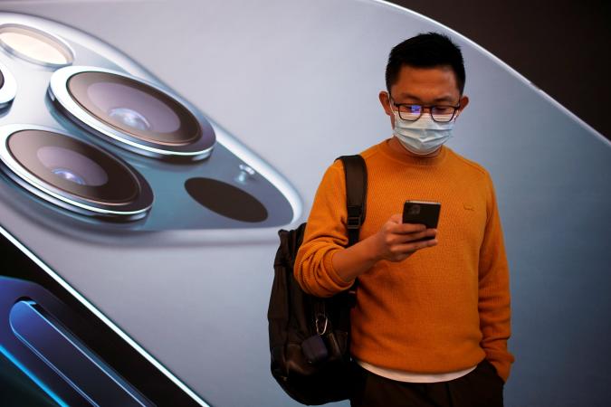A man wears a face mask while waiting at an Apple Store before Apple's 5G new iPhone 12 go on sale, as the coronavirus disease (COVID-19) outbreak continues in Shanghai China October 23, 2020. REUTERS/Aly Song