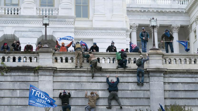 FILE - In this Jan. 6, 2021 file photo rioting supporters of President Donald Trump climb the west wall of the the U.S. Capitol in Washington. Historians say Trump’s legacy and his electoral undoing will be largely shaped by rhetoric aimed at stirring his largely white base that tugged at the long-frayed strands of race relations in America. (AP Photo/Jose Luis Magana, File)