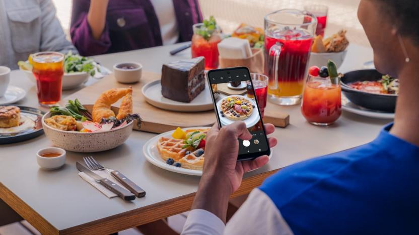 A person using the Moto G Play to take photos of waffles at a fancy breakfast.