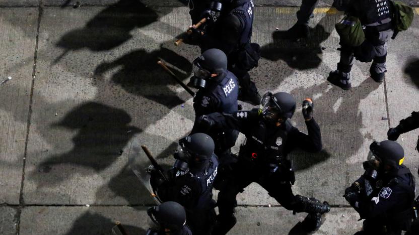 A Seattle Police officer throws a canister towards protesters during a protest against racial inequality in the aftermath of the death in Minneapolis police custody of George Floyd, near the Seattle Police department's East Precinct in Seattle, Washington, U.S. June 8, 2020. REUTERS/Lindsey Wasson