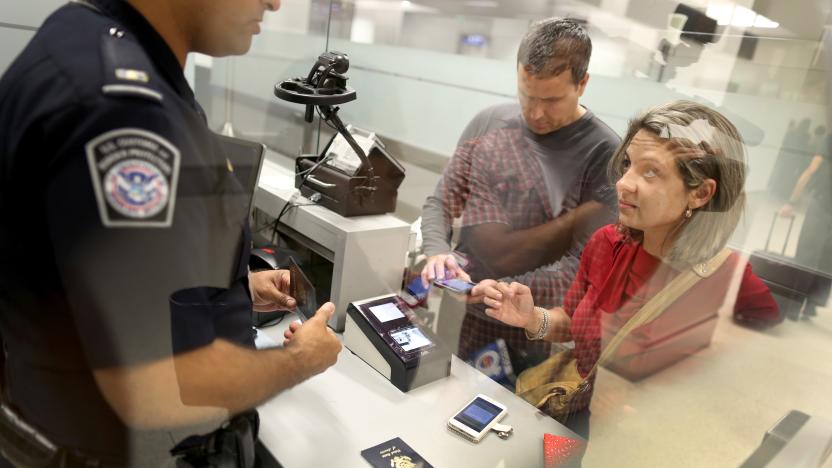 MIAMI, FL - MARCH 04:  Leonel Cordova (L) and Noris Cordova speak to a CBP officer as they try to use their new mobile app at an entry point as the program is  unveiled for international travelers arriving at Miami International Airport on March 4, 2015 in Miami, Florida. Miami-Dade Aviation Department and U.S. Customs and Border Protection (CBP) unveiled a new mobile app for expedited passport and customs screening. The app for iOS and Android devices allows U.S. citizens and some Canadian citizens to enter and submit their passport and customs declaration information using their smartphone or tablet and to help avoid the long waits in the exit lanes.  (Photo by Joe Raedle/Getty Images)