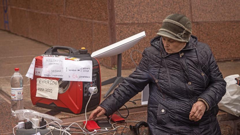 KHERSON, UKRAINE - NOVEMBER 17: A resident waits for her phone to charge at a temporary charging point and internet hotspot via a Starlink device on November 17, 2022 in Kherson, Ukraine. Ukrainian forces took control of Kherson last week, as well as swaths of its surrounding region, after Russia pulled its forces back to the other side of the Dnipro river. Kherson was the only regional capital to be captured by Russia following its invasion on February 24. 