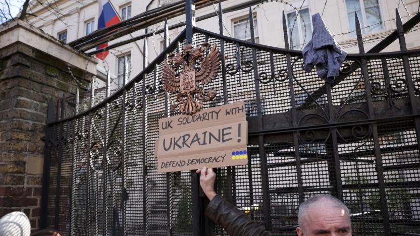 A protestor holds a sign in front of the gate of the Russian Embassy during an anti-war protest, after Russia launched a massive military operation against Ukraine, in London, Britain, February 26, 2022. REUTERS/Henry Nicholls