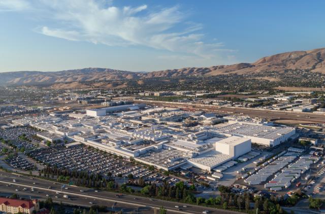 A bird's eye view of white buildings against a hilly backdrop.