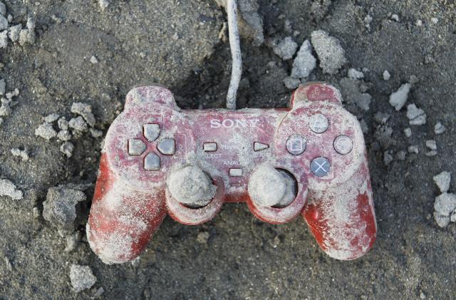 A Sony playstation controller is seen at an area that was devastated by last week's earthquake and tsunami, in Kesennuma, north Japan, March 19, 2011. REUTERS/Kim Kyung-Hoon (JAPAN - Tags: DISASTER SOCIETY)