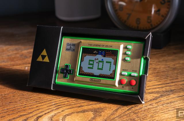 The rectangular Zelda Game & Watch sitting on an old wooden desktop.