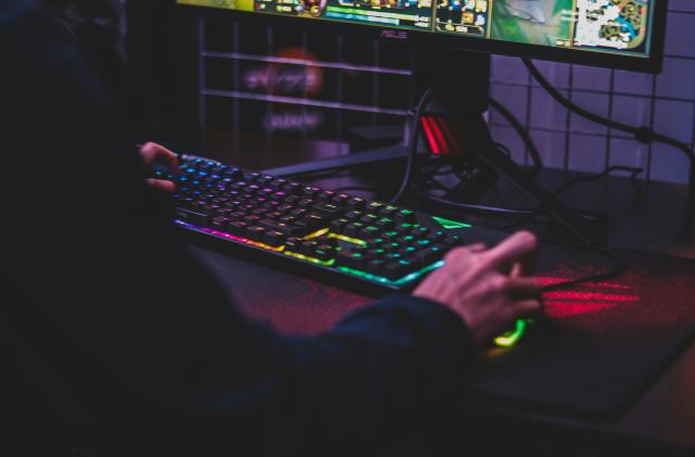 A person uses a keyboard and mouse to play a PC game.