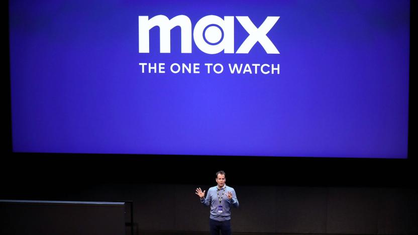 A person standing on a stage with the Max logo in the background.


