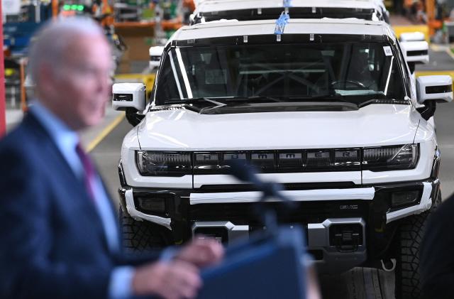 GMC Hummer EVs are seen behind President Joe Biden as he speaks during a visit to the General Motors Factory ZERO electric vehicle assembly plant in Detroit, Michigan on November 17, 2021. (Photo by MANDEL NGAN / AFP) (Photo by MANDEL NGAN/AFP via Getty Images)