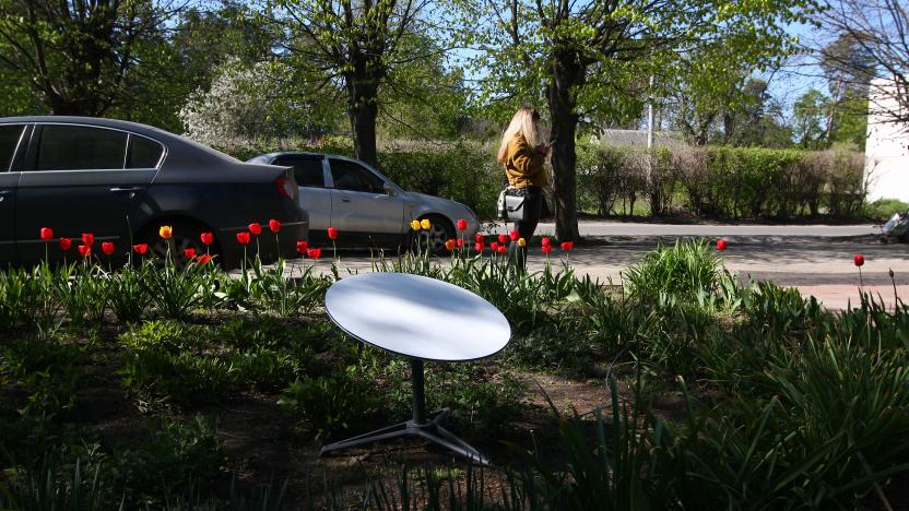 VORZEL, UKRAINE - MAY 5: A person looks at a smartphone near a SpaceX Starlink internet terminal installed on a flower bed on May 5, 2022 in Vorzel, Ukraine. During the Russian large-scale invasion of Ukraine Vorzel, an urban-type village in Kyiv Oblast, was shelled and then occupied by Russian troops in late February 2022. Until March 9, Vorzel was blocked by Russian troops, leaving most houses without electricity, heat and water. It was only on March 9 that evacuation of local residents began. On April 1, the Armed Forces of Ukraine released Vorzel. The communities northwest of Kyiv were square in the path of Russia’s devastating but ultimately unsuccessful attempt to seize the Ukrainian capital with forces deployed from Belarus, a Russian ally. (Photo by Taras Podolian/Gazeta.ua/Global Images Ukraine via Getty Images)