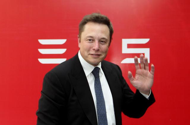 Elon Musk, CEO of Tesla Motors, waves during a news conference to mark the company's delivery of the first batch of electric cars to Chinese customers in Beijing April 22, 2014. REUTERS/Stringer (CHINA - Tags: TRANSPORT BUSINESS) CHINA OUT. NO COMMERCIAL OR EDITORIAL SALES IN CHINA