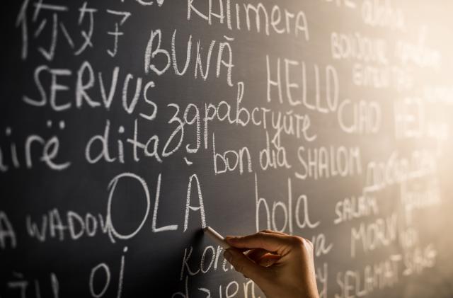 Hello in many languages written with chalk on blackboard