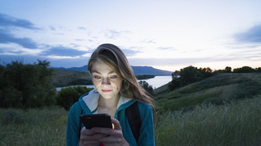 Teenage girl using her smart phone while hiking