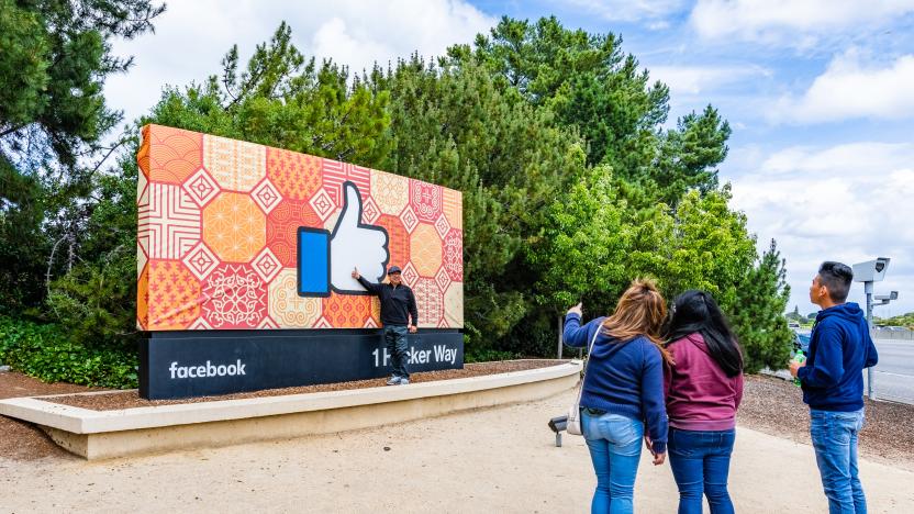 May 26, 2019 Menlo Park / CA / USA - Tourists posing in front of the Facebook Like Button sign located at the entrance to the company's main headquarters located in Silicon Valley (1 Hacker Way);