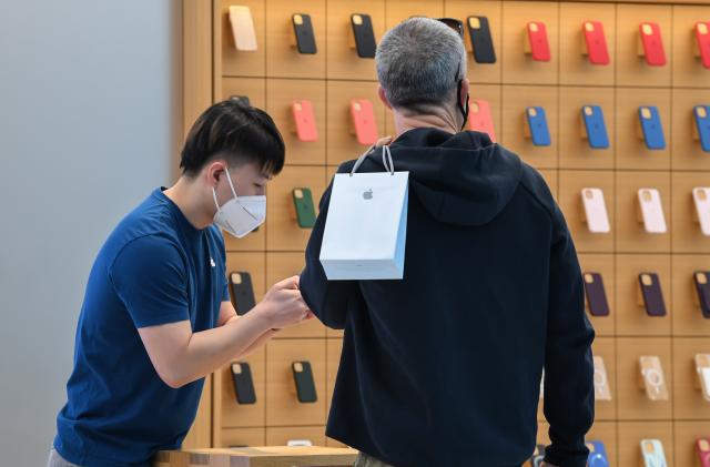 SYDNEY, AUSTRALIA - SEPTEMBER 24: A man holds his bag containing his new iPhone as he talks to an Apple Store staff member on September 24, 2021 in Sydney, Australia. The new Apple iPhone 13 and iPhone 13 Pro went on sale at Apple Sydney in Australia today. iPhone 13 Pro offers customers the most advanced camera system ever on iPhone, a Super Retina XDR display with ProMotion and is powered by A15 Bionic, the fastest chip in a smartphone. Additionally the iPad mini and a new iPad also went on sale today. Due to current COVID-19 lockdown restrictions in Sydney, customers are able to pick up their pre-ordered products with click and collect, but are not able to shop in-store. (Photo by James D. Morgan/Getty Images)