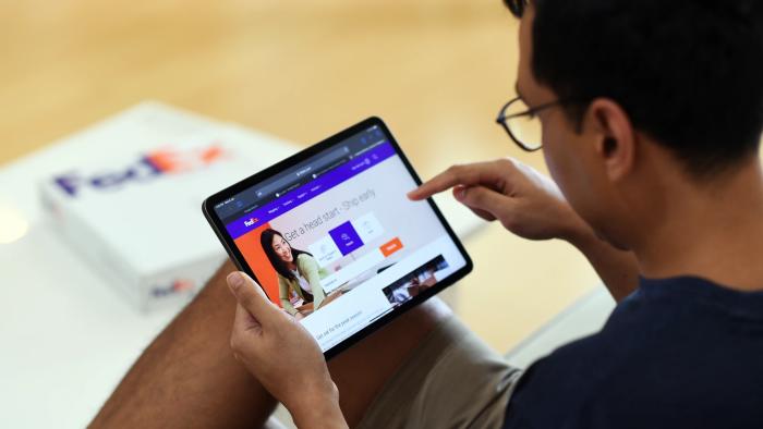 a person browses the FedEx website on a tablet