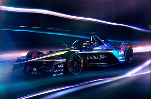 Formula E Gen3 Evo race car in motion with blurred lights all around it. 