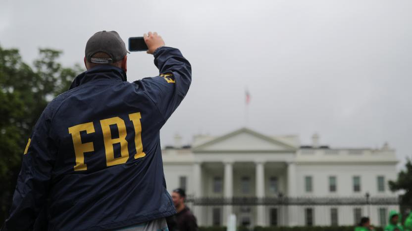 A tourist wearing an FBI jacket stands outside of the White House during a rainy day in Washington, U.S., May 17, 2018. REUTERS/Carlos Barria