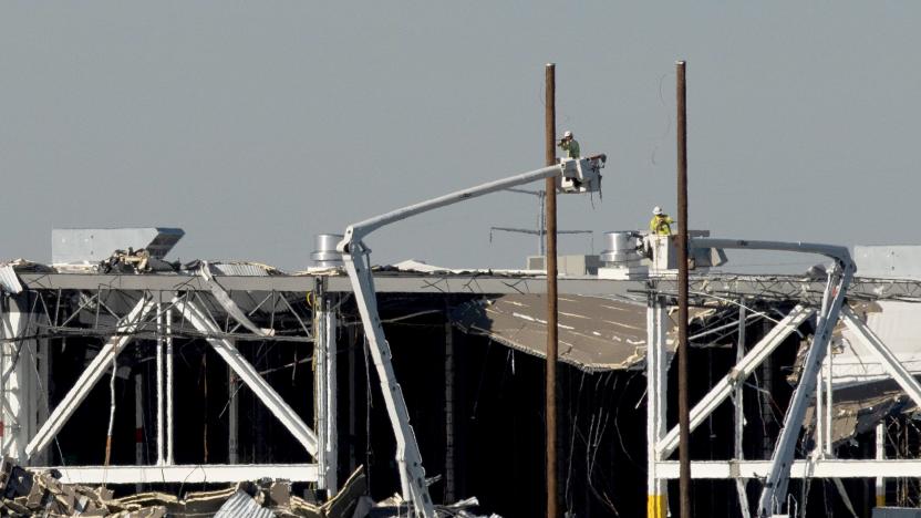 Amazon crew on lifts document the damage from the tornado that hit an Amazon distribution centre where the roof collapsed in Edwardsville, Illinois, U.S. December 13, 2021.  REUTERS/Lawrence Bryant