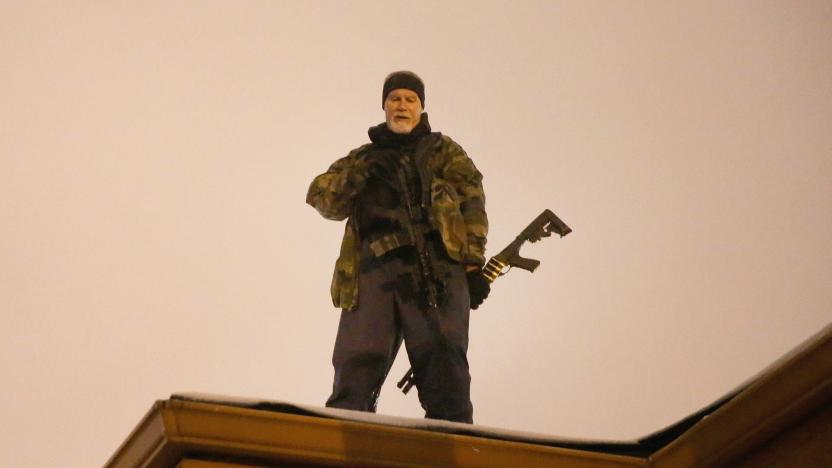 FERGUSON, MO - NOVEMBER 26:  John Karriman. a volunteer from Oath Keepers, stands guard on the rooftop of a  business on November 26, 2014 in Ferguson, Missouri. Demonstrators looted and burned down several businesses along the street on Monday after the grand jury announced its decision in the Michael Brown case. Brown, an 18-year-old black man, was killed by Darren Wilson, a white Ferguson police officer, on August 9. (Photo by Scott Olson/Getty Images)