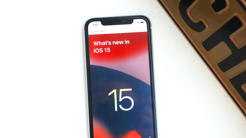 An iPhone XR laying on a white surface showing "What's new in iOS 15" on its screen.
