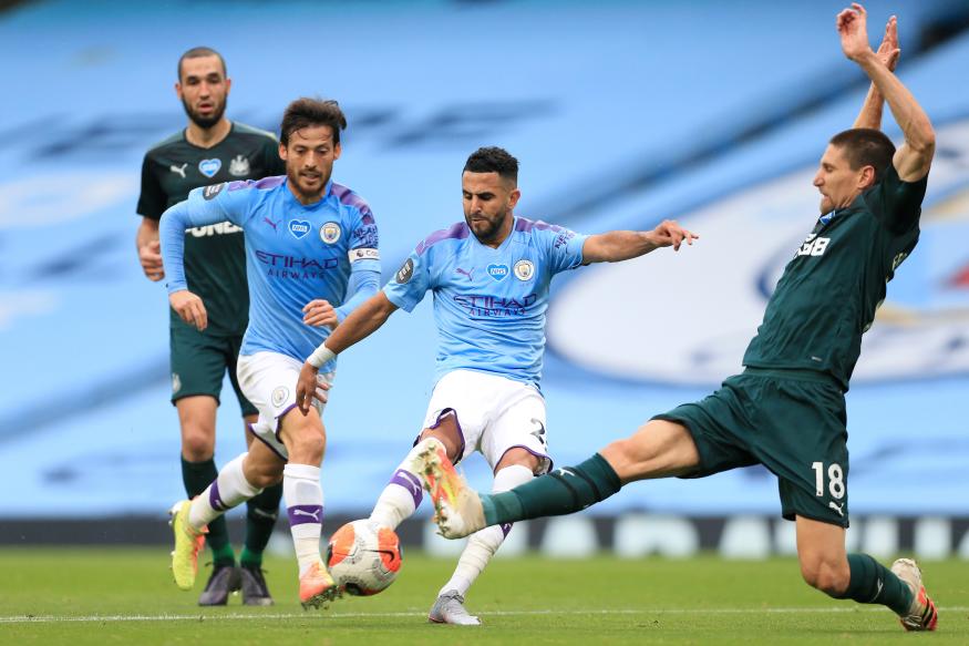 MANCHESTER, ENGLAND - JULY 08: Riyad Mahrez of Man City shoots as Federico Fernandez of Newcastle lunges in to challenge during the Premier League match between Manchester City and Newcastle United at Etihad Stadium on July 8, 2020 in Manchester, United Kingdom. (Photo by Simon Stacpoole/Offside/Offside via Getty Images)