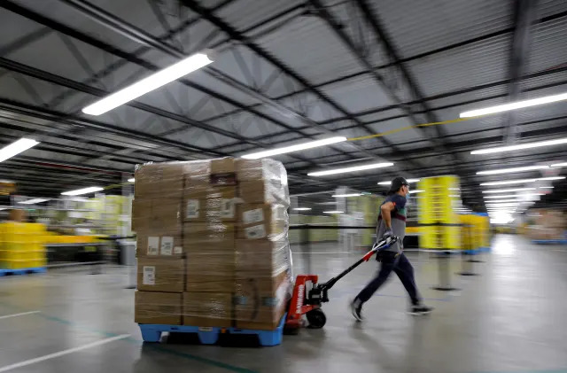 An employee pulls a cart full of items at Amazon's JFK8 distribution center in Staten Island, New York, U.S. November 25, 2020.  REUTERS/Brendan McDermid.     TPX IMAGES OF THE DAY
