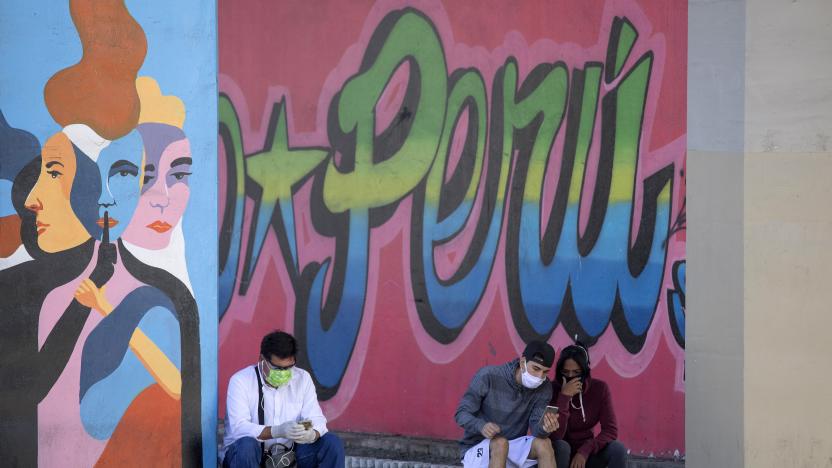 LIMA, PERU - APRIL 24: People wearing face masks check their mobile phones in the street during coronavirus lockdown on April 24, 2020 in Lima, Peru. After 40 days of government-ordered lockdown and over 20,000 positive cases registered, President Vizcarra extended protective measures until May 10.  (Photo by Stringer/Getty Images)