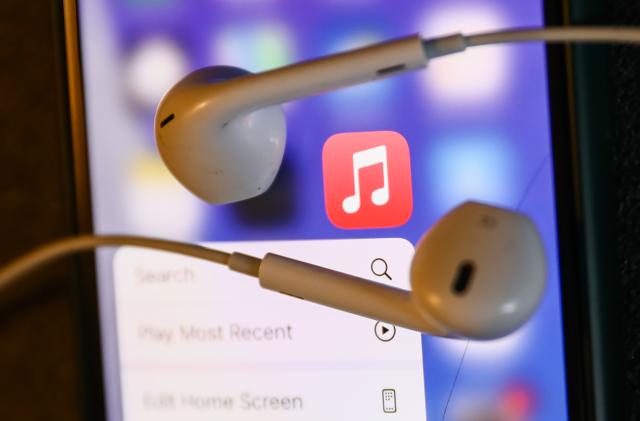 Apple Music icon displayed on a phone and headphones are seen in this illustration photo taken in Krakow, Poland on August 22, 2022. (Photo by Jakub Porzycki/NurPhoto via Getty Images)