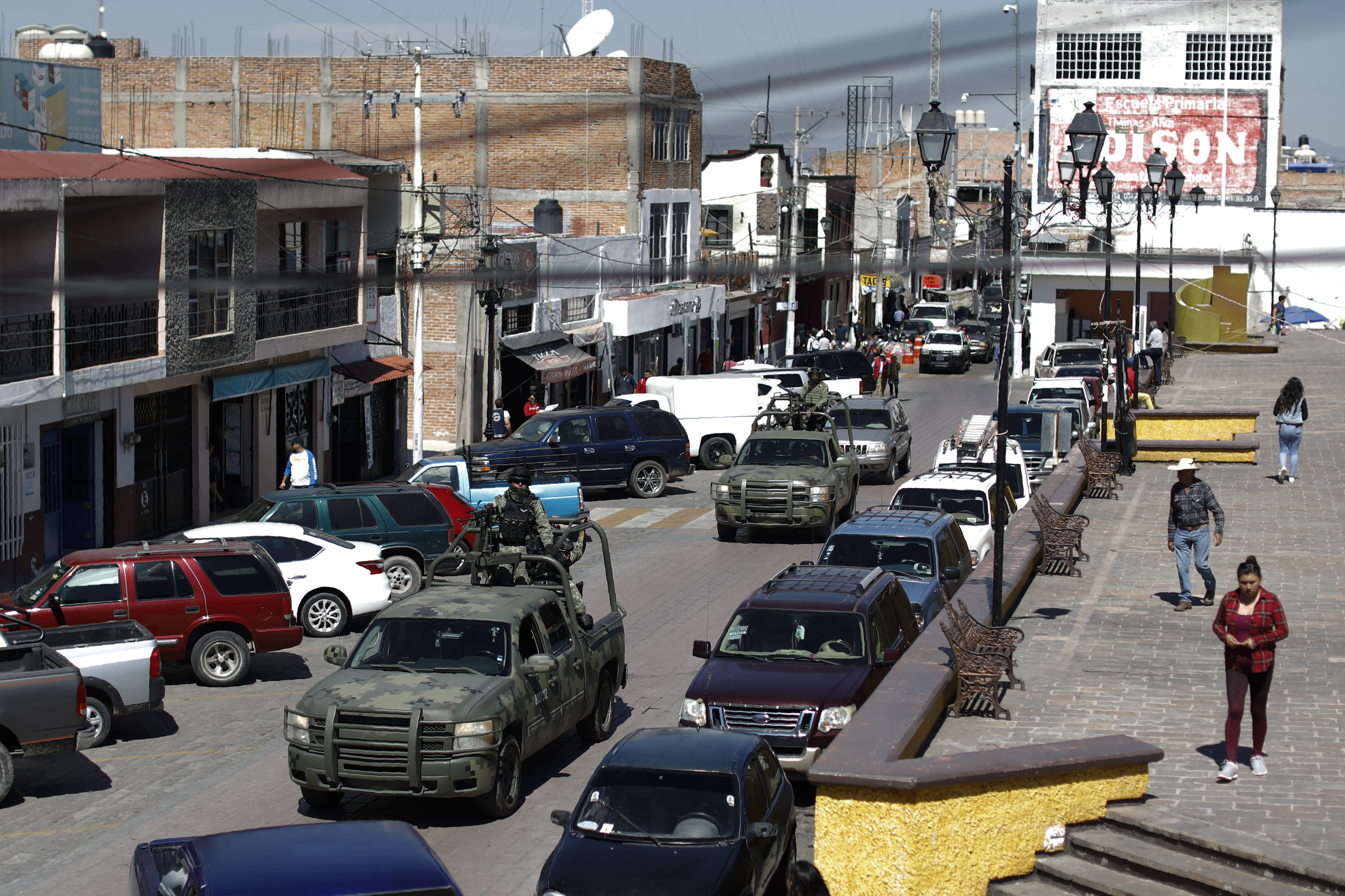 FILE - In this Feb. 10, 2020 file photo, National Guard patrol vehicles drive through the central square in Apaseo el Alto, Guanajuato state, Mexico. The two most powerful drug cartels in the hemisphere are battling over this industrial and farming hub of central Mexico — a state that has attracted gangs for the same reason it has lured auto manufacturers: road and rail networks that lead straight to the U.S. border. (AP Photo/Rebecca Blackwell, File)