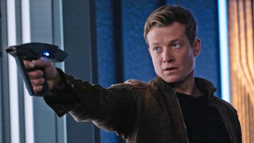 Ed Speelers as Jack in "Disengage" Episode 302 of 'Star Trek: Picard' aims his phaser at a target offscreen.