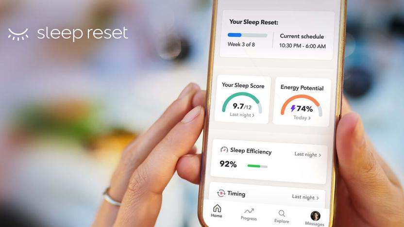 Hands holding a phone showing the Sleep Reset app against a blurred background. The app screen displays the user's sleep score, energy potential and sleep efficiency charts.