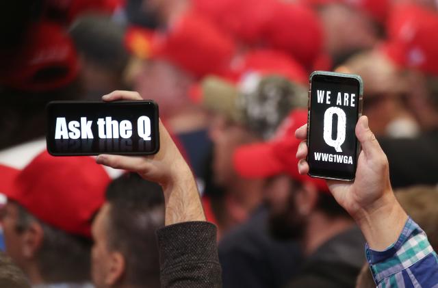 LAS VEGAS, NEVADA - FEBRUARY 21: Supporters of President Donald Trump hold up their phones with messages referring to the QAnon conspiracy theory at a campaign rally at Las Vegas Convention Center on February 21, 2020 in Las Vegas, Nevada. The upcoming Nevada Democratic presidential caucus will be held February 22. (Photo by Mario Tama/Getty Images)