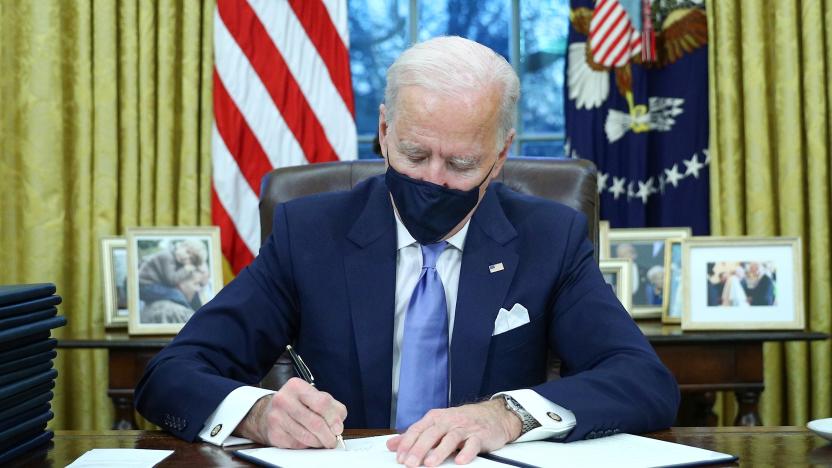 U.S. President Joe Biden signs executive orders in the Oval Office of the White House in Washington, after his inauguration as the 46th President of the United States, U.S., January 20, 2021. REUTERS/Tom Brenner