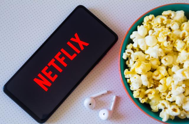 BRAZIL - 2022/04/19: In this photo illustration, the Netflix logo seen displayed on a smartphone along with a bowl of popcorn and headphones. (Photo Illustration by Rafael Henrique/SOPA Images/LightRocket via Getty Images)