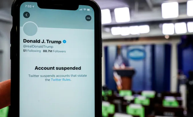 A photo illustration shows the suspended Twitter account of U.S. President Donald Trump on a smartphone at the White House briefing room in Washington, U.S., January 8, 2021.  REUTERS/Joshua Roberts/Illustration